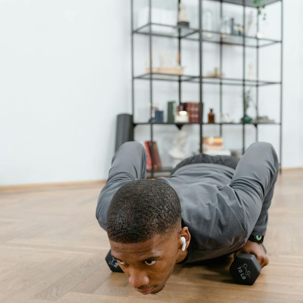 Man in a focused stance during a bodyweight exercise.