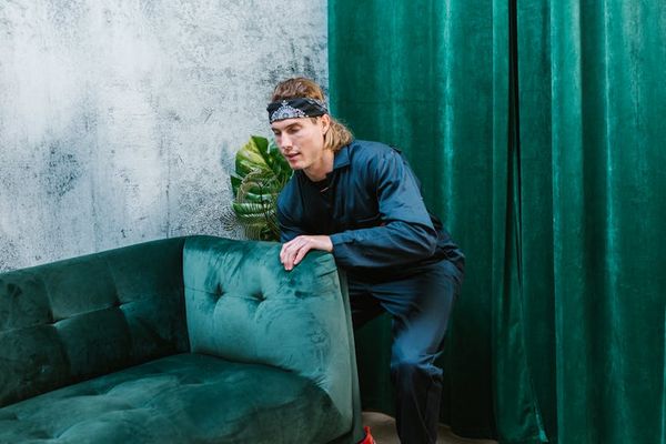 Man performing a controlled bodyweight exercise in a minimalist room.